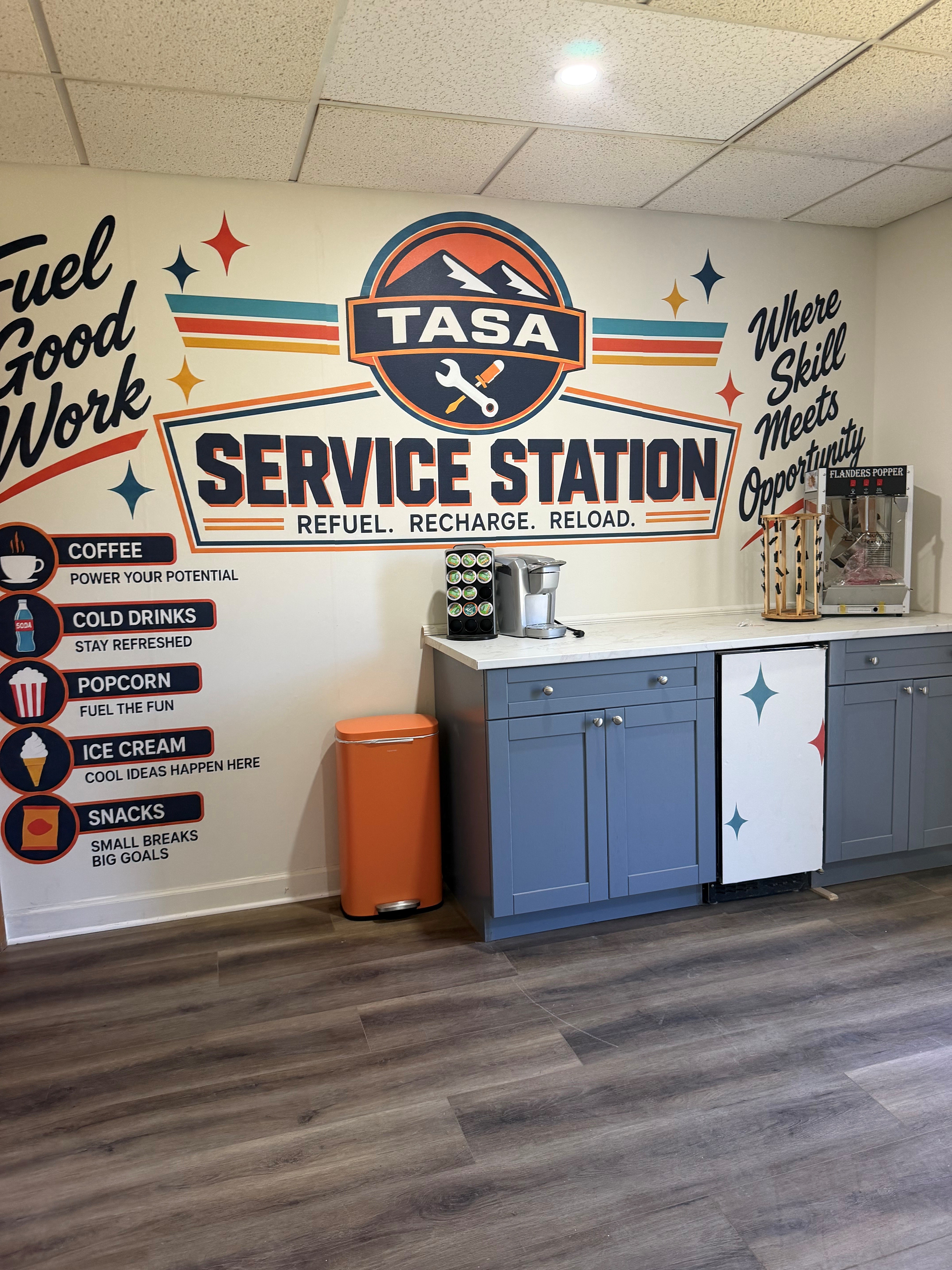 TASA student break room with service-station mural, refreshments, and seating